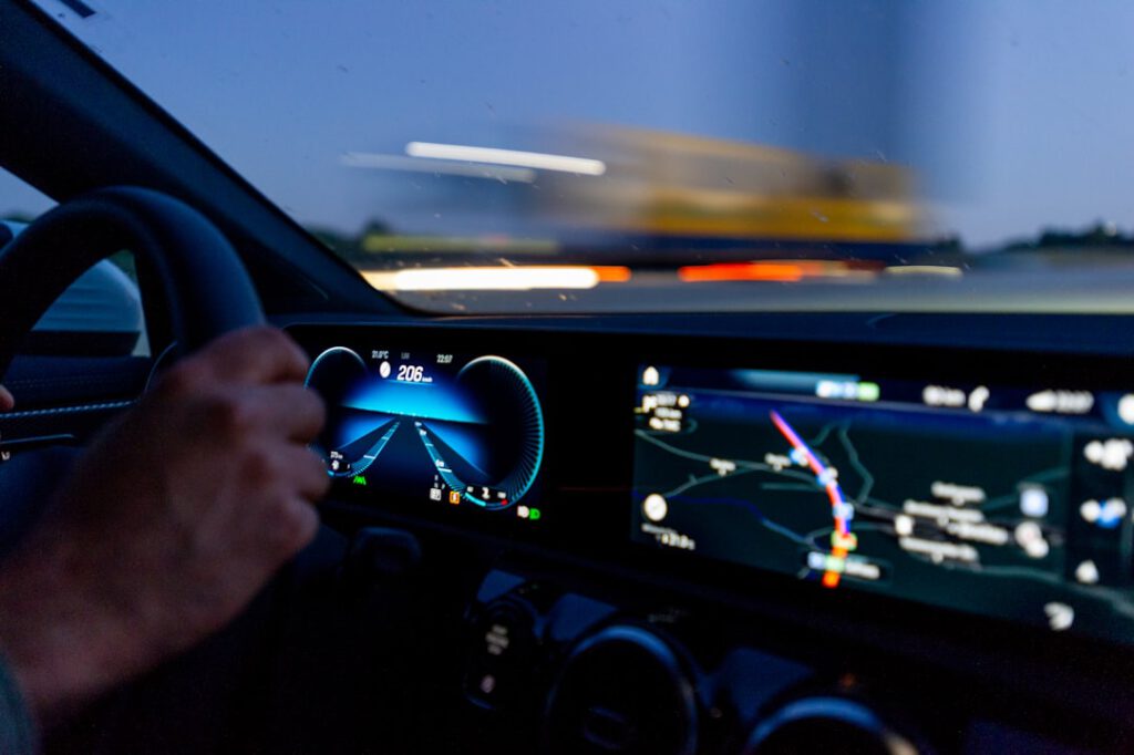 Hand aan het stuur in een auto met dashboard